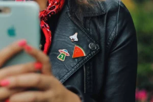 Woman wearing a leather jacket with custom lapel pins adhered to it