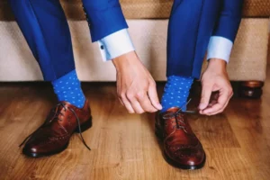 Man tie his shoes showing off his blue custom socks