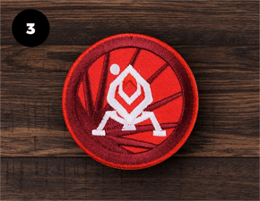 Red custom embroidered patch on dark wood background