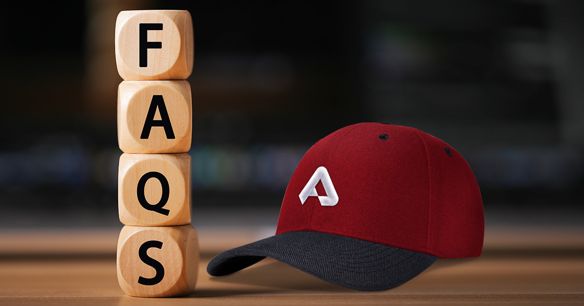 a wooden block with the words FAQS on them next to a red hat